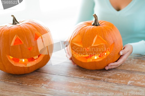 Image of close up of woman with pumpkins at home