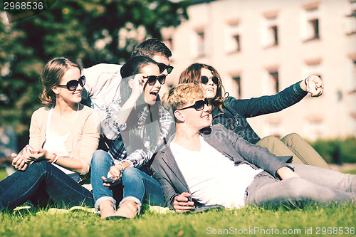 Image of teenagers taking photo outside with smartphone