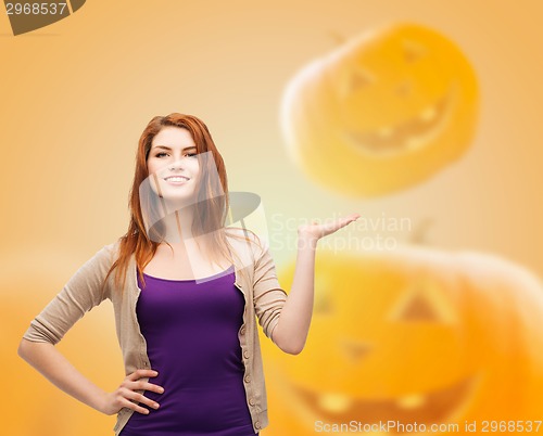 Image of smiling teenage girl holding something on her palm