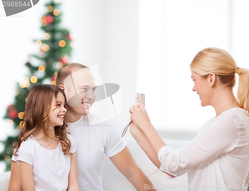 Image of happy family with camera at home