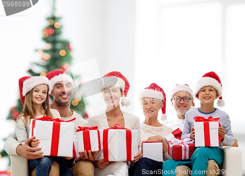 Image of happy family in santa helper hats with gift boxes