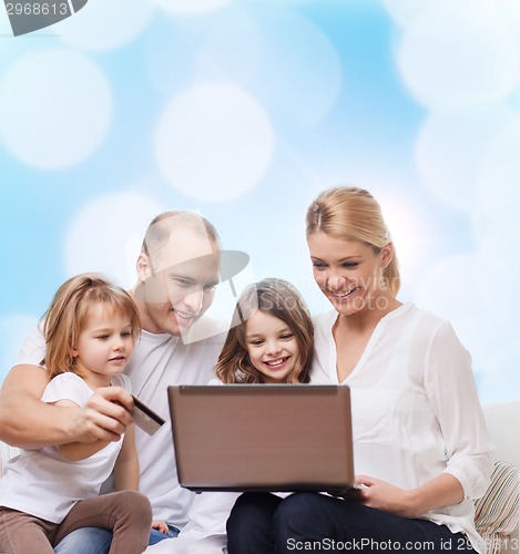 Image of happy family with laptop computer and credit card