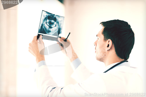 Image of male doctor or dentist looking at x-ray