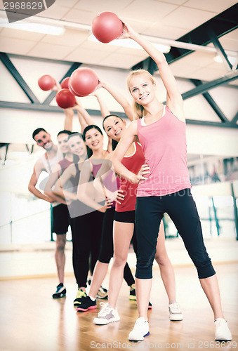 Image of group of smiling people working out with ball