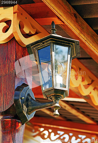 Image of The lantern on the wall decorated with wooden carvings