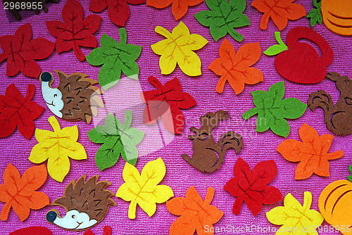 Image of Hedgehog, squirrel and leaves out of felt on a pink fabric as a 