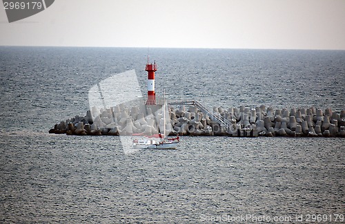 Image of a lighthouse and a small yacht