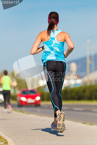 Image of Young girl runner on the street.