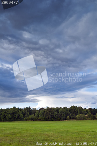 Image of Landscape with grey clouds and green grass