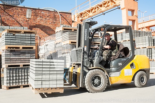 Image of Driver on lift truck loads products of plant