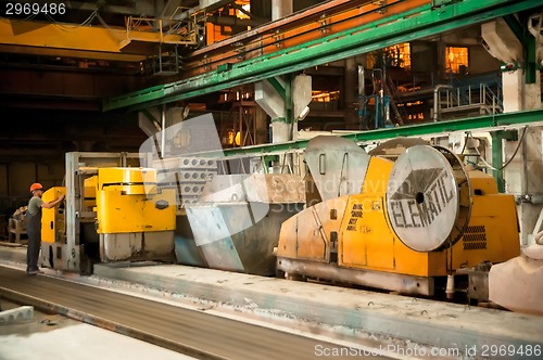 Image of Worker works at machine on production of plates