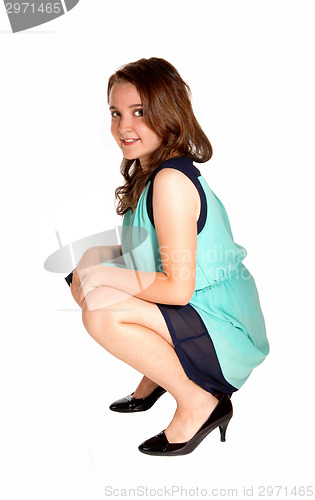 Image of Teen girl crouching on floor.