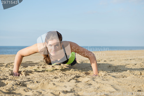 Image of Woman pushing up on a beach