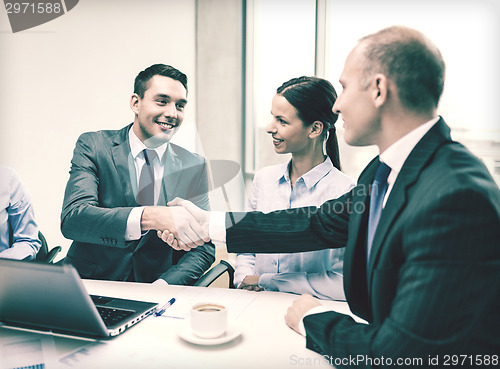 Image of two businessman shaking hands in office