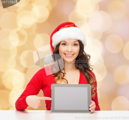 Image of smiling woman in santa hat with gift and tablet pc