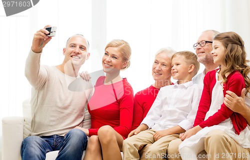 Image of smiling family with camera at home