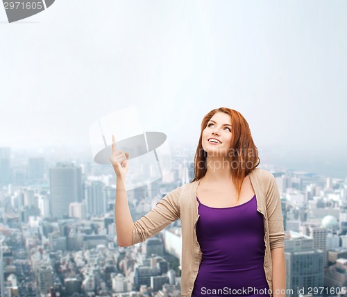 Image of smiling teenage girl pointing finger up