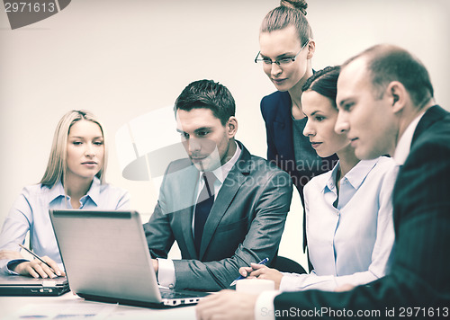 Image of business team with laptop having discussion