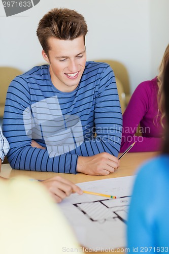 Image of group of smiling students with blueprint