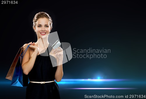 Image of smiling woman with shopping bags and credit card