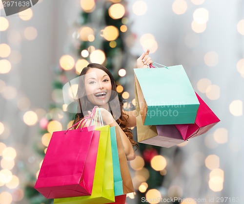 Image of smiling woman with colorful shopping bags