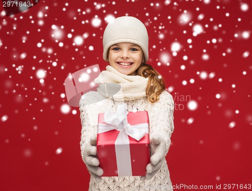 Image of girl in hat, muffler and gloves with gift box