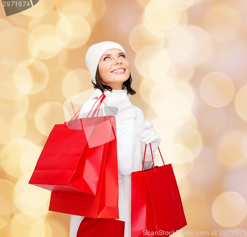 Image of smiling young woman with red shopping bags