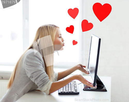 Image of woman sending kisses with computer monitor