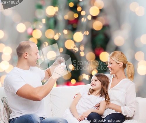 Image of happy family with camera at home
