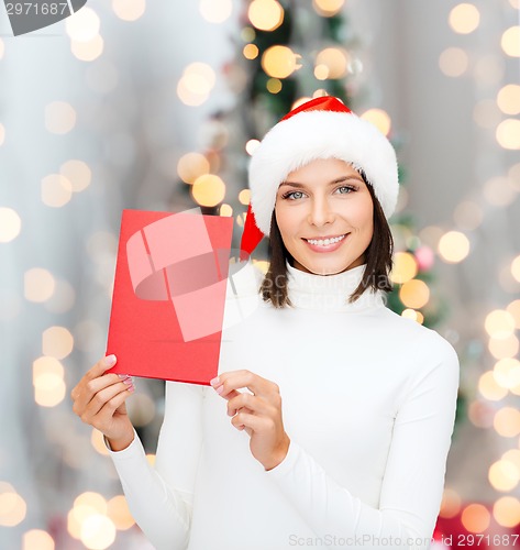 Image of smiling woman in santa hat with greeting card