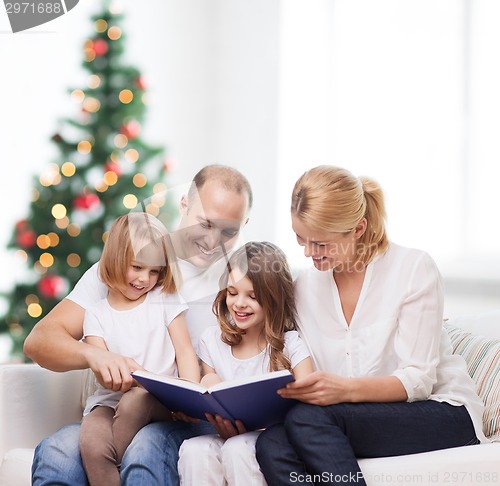 Image of happy family with book at home