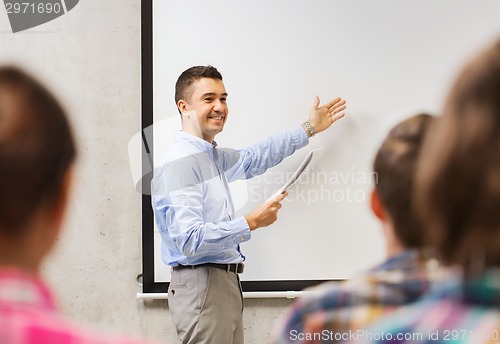 Image of group of students and smiling teacher with notepad