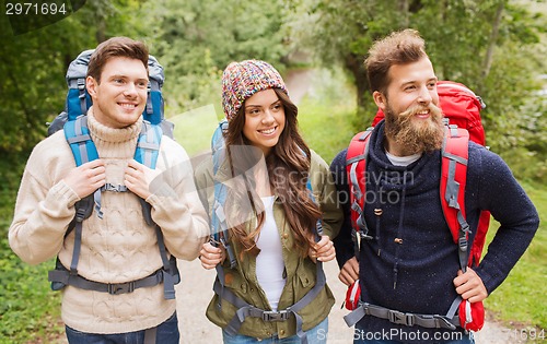 Image of group of smiling friends with backpacks hiking