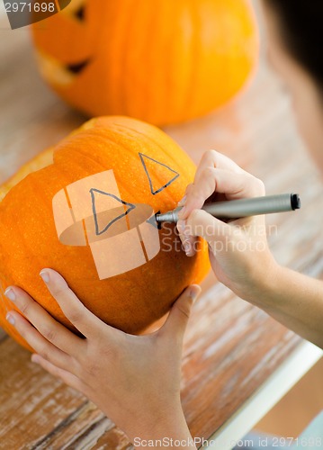 Image of close up of woman with pumpkins at home