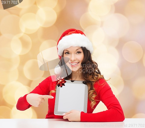 Image of smiling woman in santa hat with gift and tablet pc