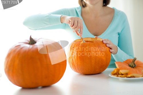 Image of close up of woman with pumpkins at home