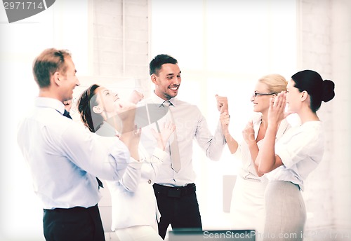 Image of business team celebrating victory in office