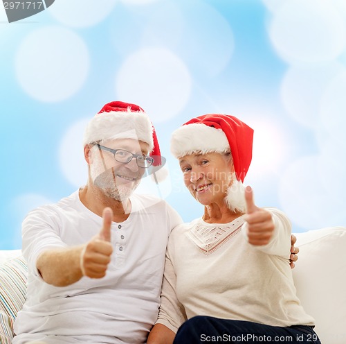 Image of happy senior couple in santa helper hats
