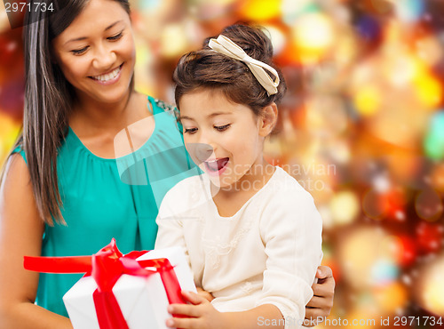 Image of happy mother and little girl with gift box