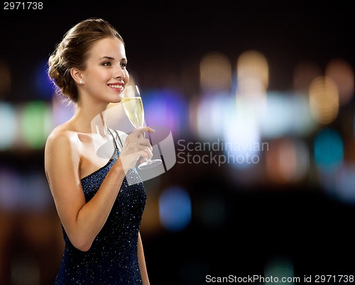 Image of smiling woman holding glass of sparkling wine