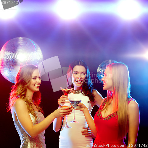 Image of three smiling women with cocktails and disco ball