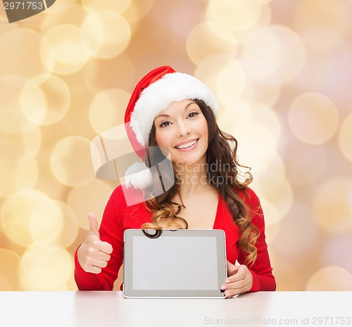 Image of smiling woman in santa hat with gift and tablet pc