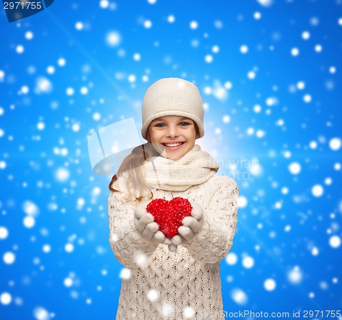 Image of dreaming girl in winter clothes with red heart