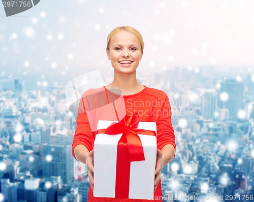 Image of smiling woman in red clothes with gift box