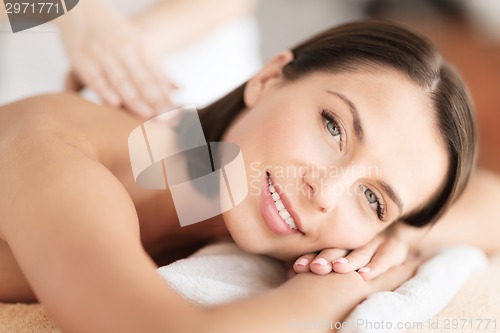 Image of beautiful woman in spa salon getting massage