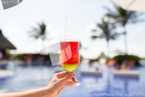 Image of close-up of hand holding glass with cocktail