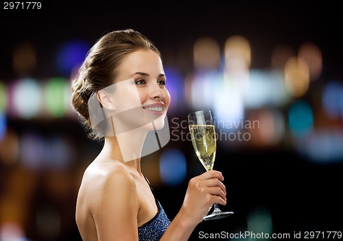 Image of smiling woman holding glass of sparkling wine