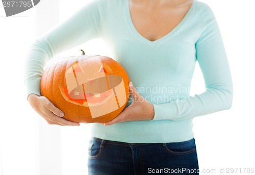 Image of close up of woman with pumpkins at home