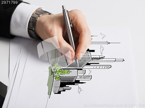 Image of close up of male hand with pen drawing graph