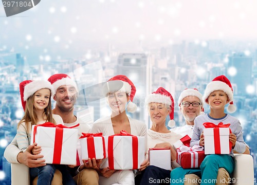 Image of happy family in santa helper hats with gift boxes